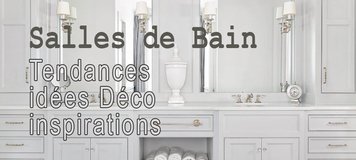 Les Plus Belles Salles de bain élégante avec meuble-lavabo double gris clair, grands miroirs encadrés, appliques murales classiques, rangements symétriques, serviettes blanches roulées dans une niche centrale et sol en marbre à motif géométrique.