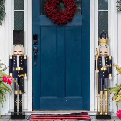 2 Casse-noisettes de Noël en bois de 1,2 m de hauteur pour Décoration de Noël devant une porte d'entrée bleu décoré par une couronne de noel rouge