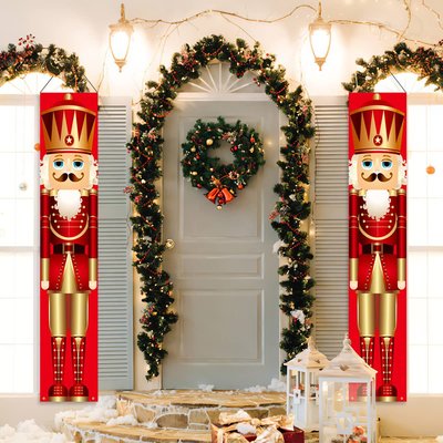 Décorations de Noël Casse-Noisette rouge de chaque coté d'une porte d'entrée décoré d'une guirlande du temps des fêtes