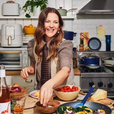 Drew Barrymore cuisinant un repas avec une poele de sa Collection Beautiful