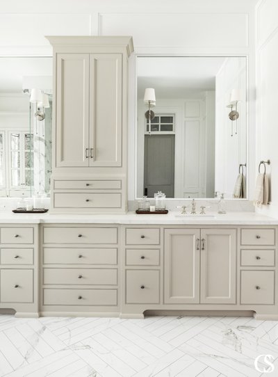 Salle de bain élégante avec meuble-lavabo double beige, nombreux tiroirs et armoires, comptoir en marbre blanc