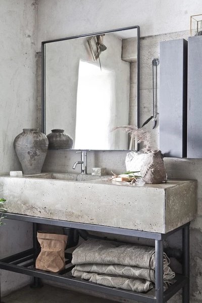 Réalisation de l'entreprise Ferland Drouin - Salle de bain au style industriel avec un lavabo en béton, un miroir rectangulaire, des accessoires en céramique rustique et un rangement en métal noir