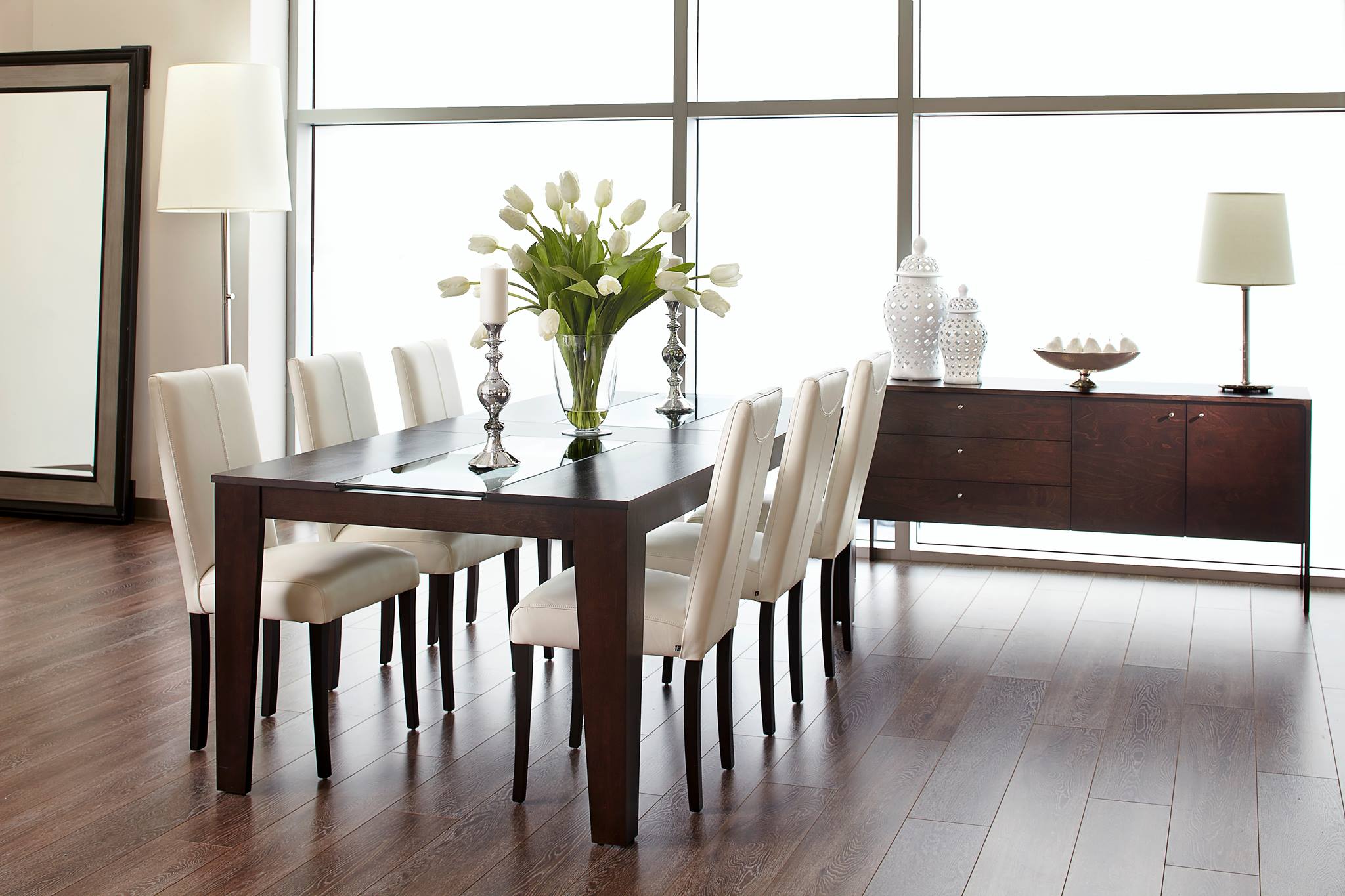 Salle à manger moderne avec table en bois foncé, chaises blanches et décor épuré de chez l'entreprise Verbois.