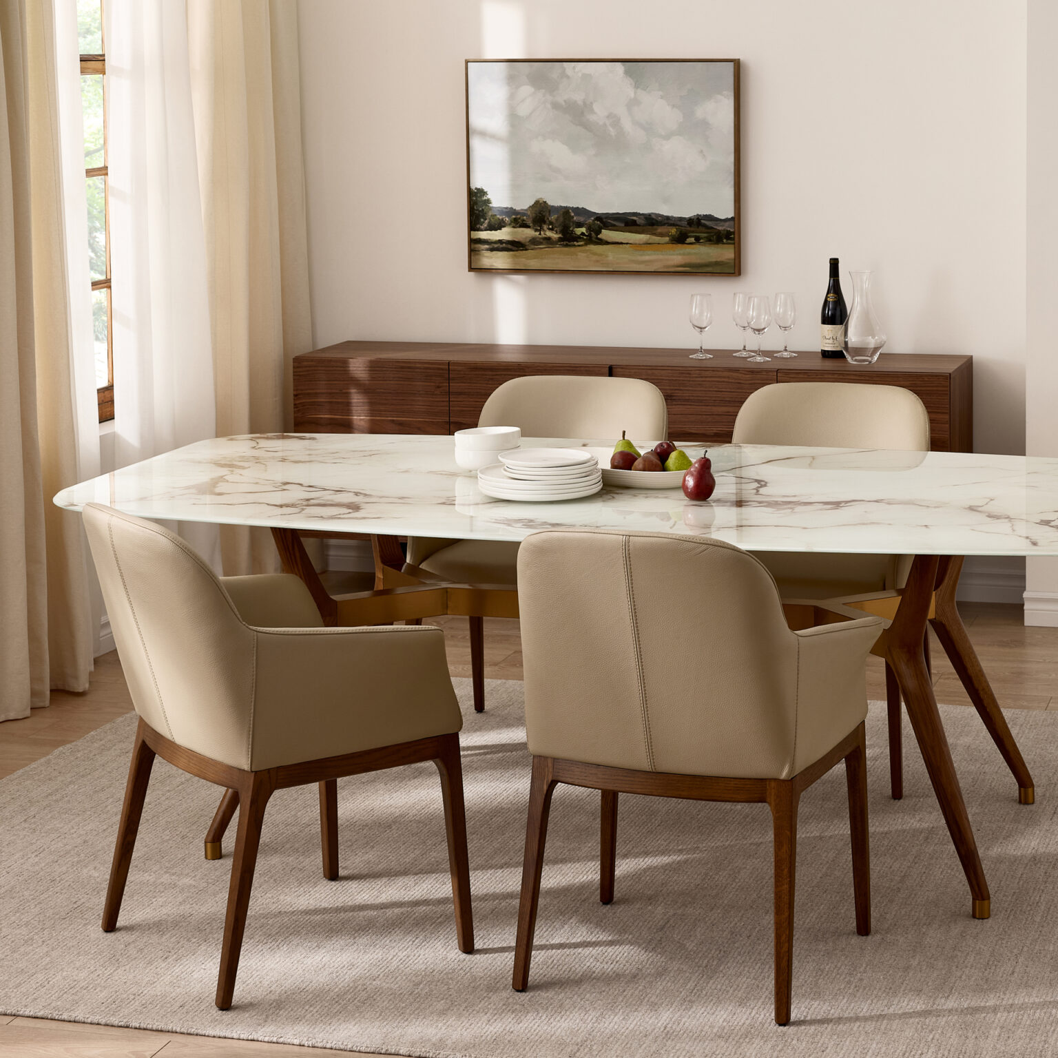 Salle à manger moderne avec table en marbre blanc, chaises rembourrées beige et pieds en bois, buffet en bois et décoration lumineuse.